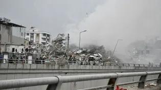 Collapsed buildings and smoke show the aftermath of an earthquake