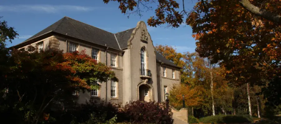 University of Edinburgh Crewe Building, showing a two storey building with front steps surrounded by autumn trees