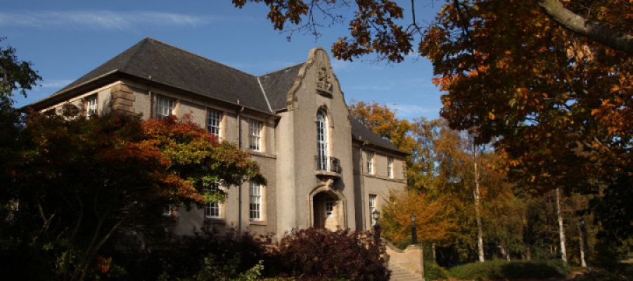 University of Edinburgh Crewe Building, showing a two storey building with front steps surrounded by autumn trees