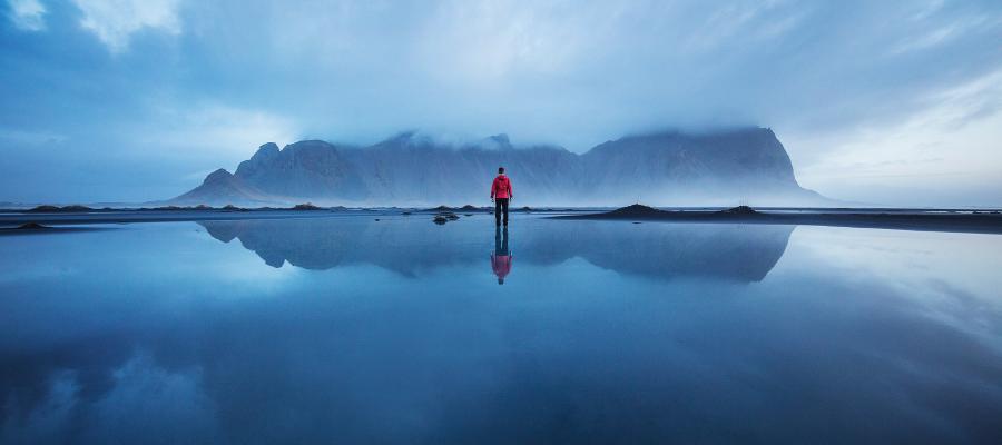 Person standing in front of iceberg