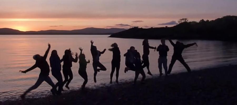 Group of students on the beach posing for a photograph