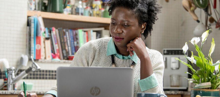 Woman sitting at a laptop taking notes