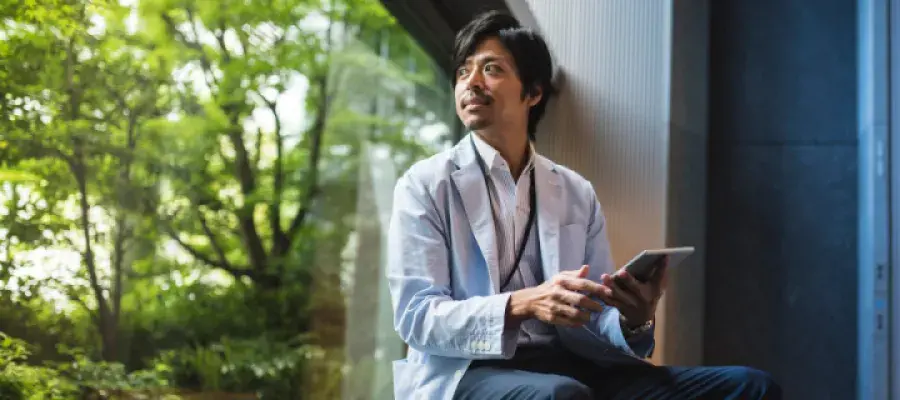 Man with iPad sitting by window