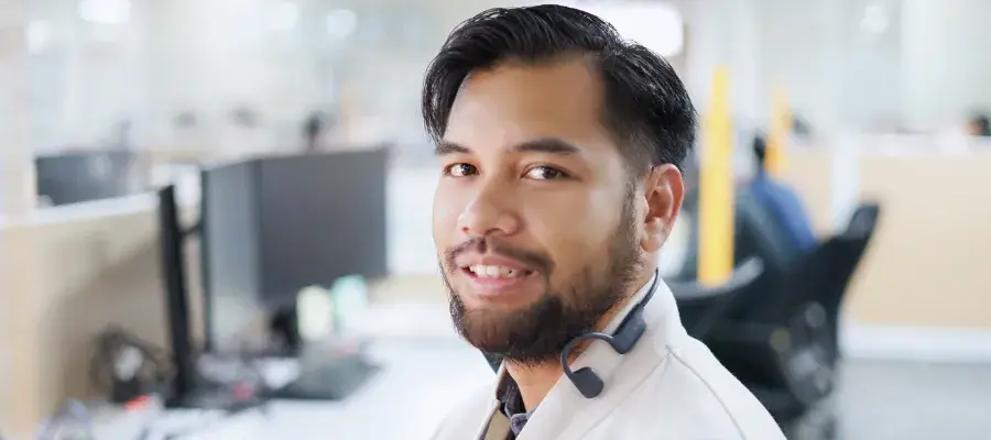 Rizky smiles for the camera while in a computer room