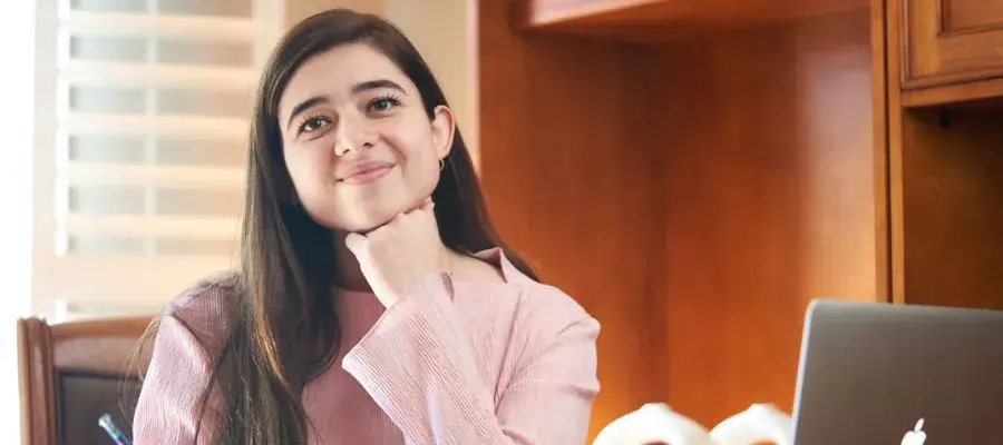 Mia sitting at a desk and smiling for the camera