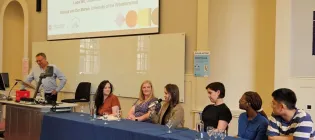A group of people sitting at a table for a panel discussion