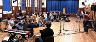 An orchestra containing young musicians pictured performing
