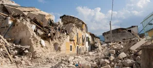 The destruction of an earthquake is shown by collapsed buildings and debris in the street