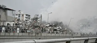 Collapsed buildings and smoke show the aftermath of an earthquake