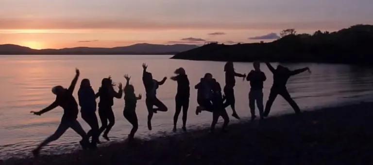 Group of students on the beach posing for a photograph