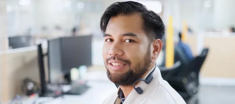 Rizky smiles for the camera while in a computer room
