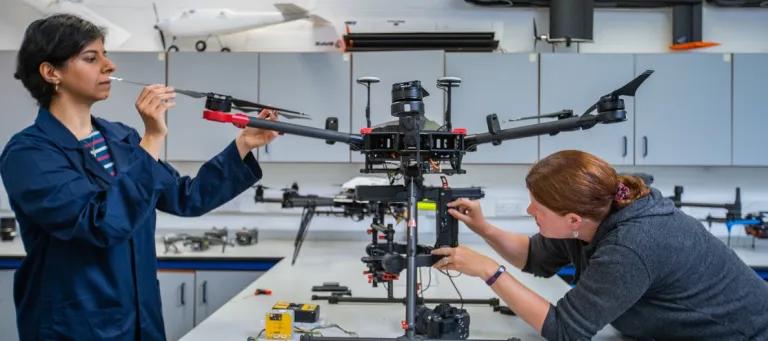 Students inspecting a drone.