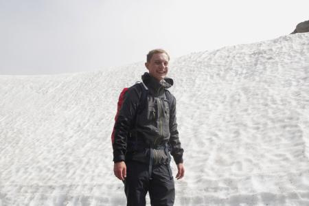 Vojta standing in front of a snow-covered hill and smiling for the camera.