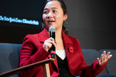 Lauren at Cop26 talk, sitting on a chair on stage with a microphone