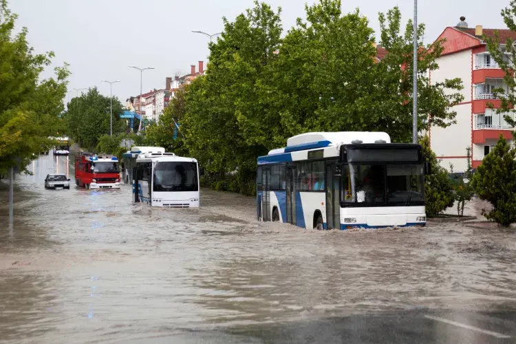 Buses stopped in a flooded road with a fire engine in the background