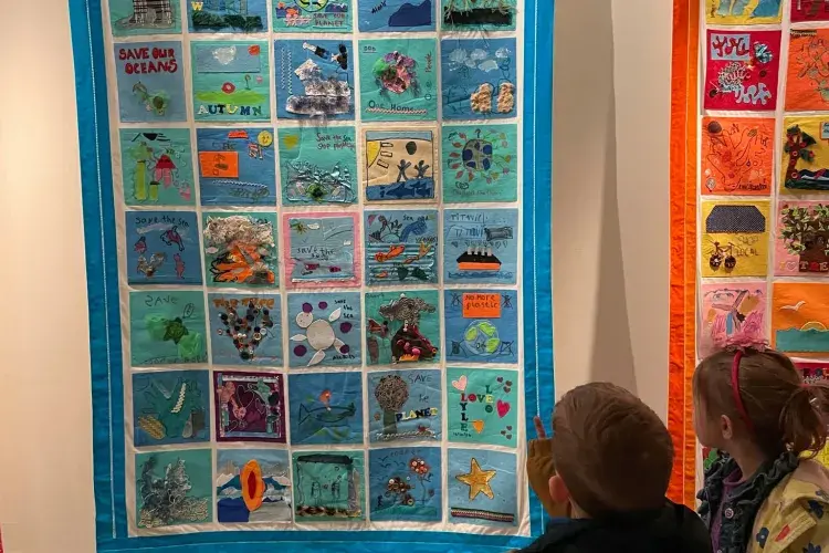 Two children viewing one of the finished quilts
