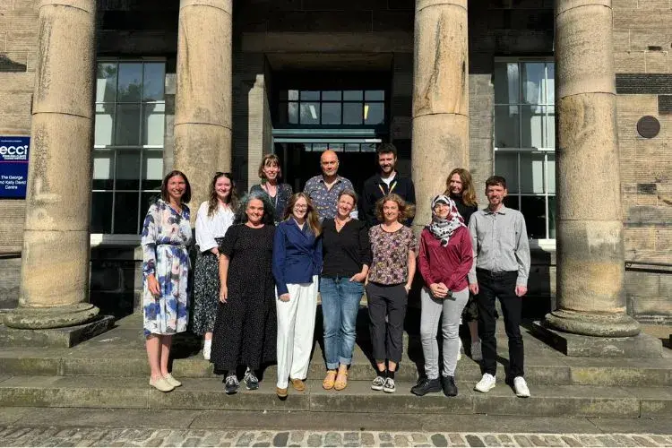 The SCIS team stand on the ECCI steps for a photograph
