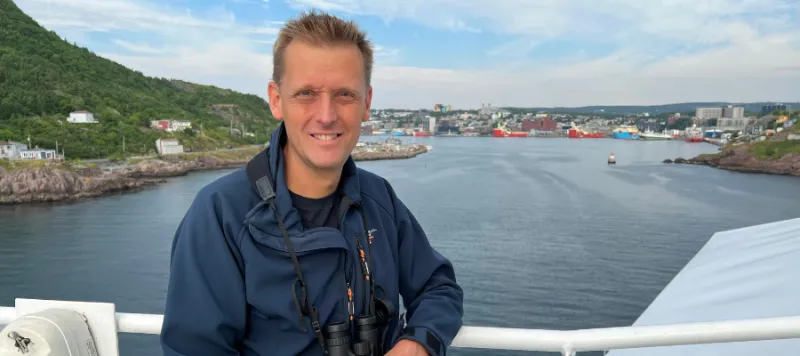 Murray poses for a photo with a lake in the background.