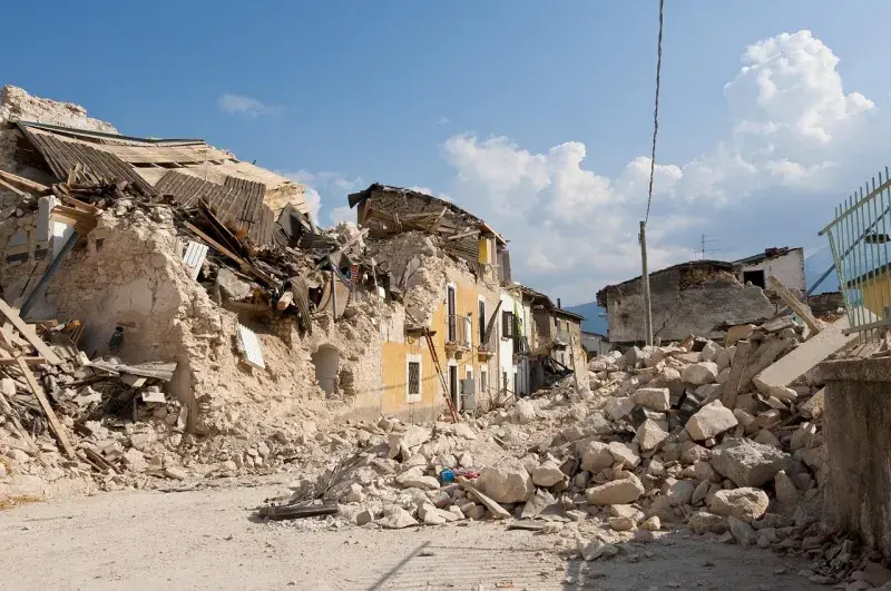 The destruction of an earthquake is shown by collapsed buildings and debris in the street