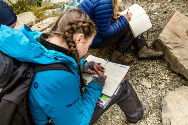 Erin sketching a diagram in her notebook.
