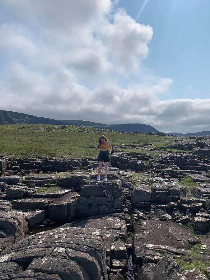 Erin pictured walking along a rocky landscape.