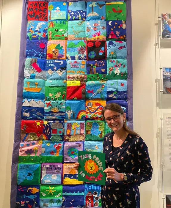 Sian Henley standing in front of one of the finished quilts