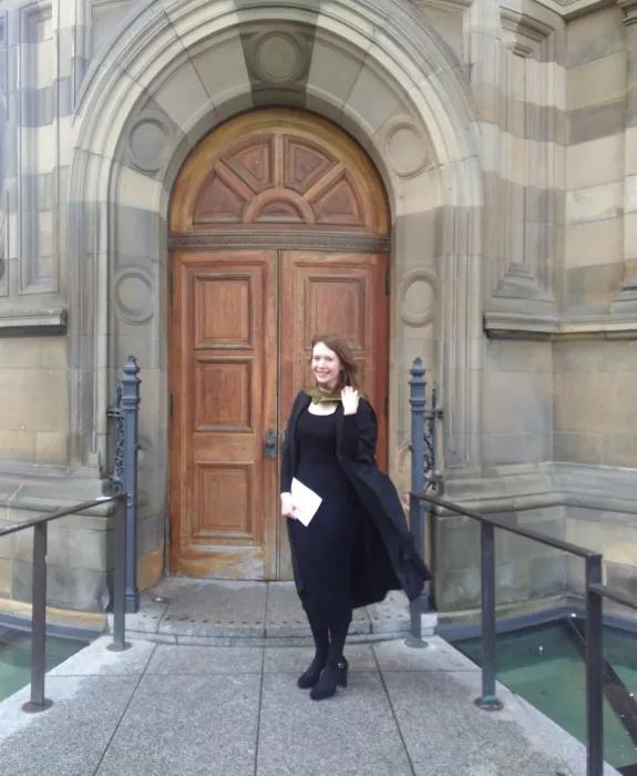 Sarah poses for a photo outside the McEwan Hall doors in her graduation gown