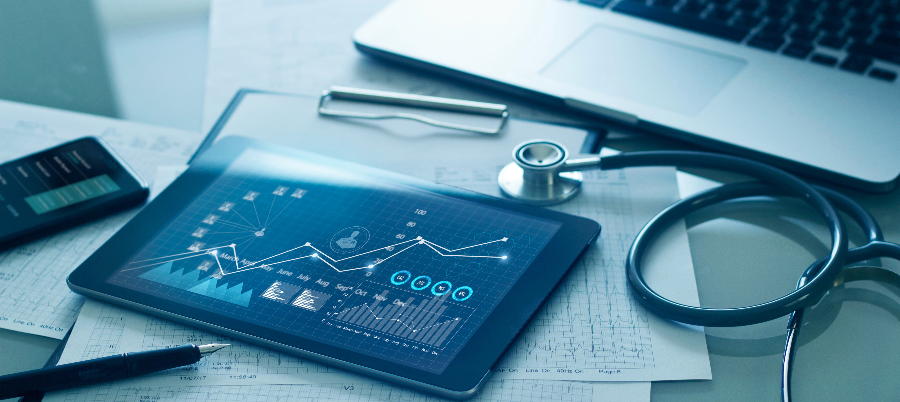 Medical examination and growth graph data of business on tablet with doctor's health report clipboard and laptop in background.