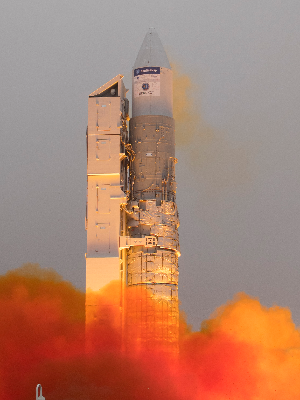 A rocket blasting off it's launch pad into space, with smoke and flame bursting out from it's exhaust