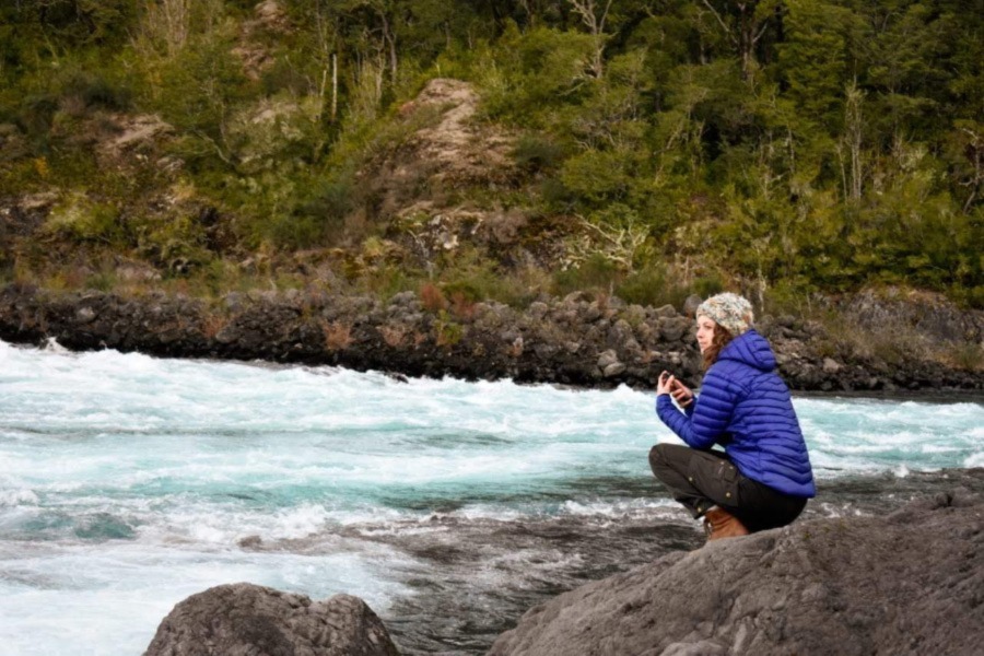 Rebekah Harries sits on the banks of a river